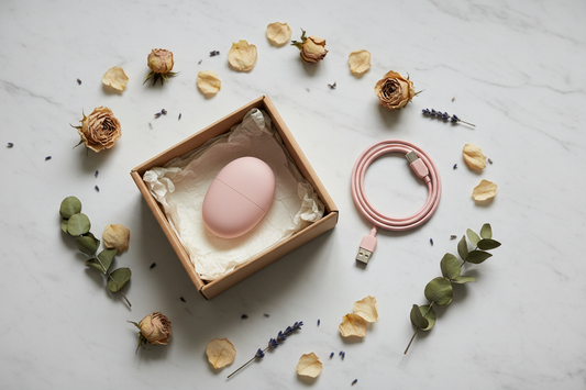 Objeto compacto en rosa blush en caja kraft con flores secas y cable USB — Juguetes sexuales discretos con envío neutro México 2026